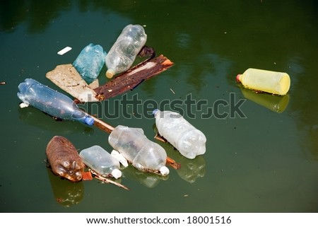 plastic bottle pollution on water, focus on the front