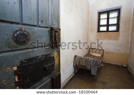 dynamic view of old prison cell with door,bed, clothes