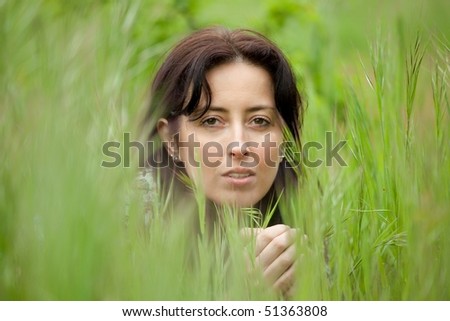 beautiful woman portrait hidden in blade grass