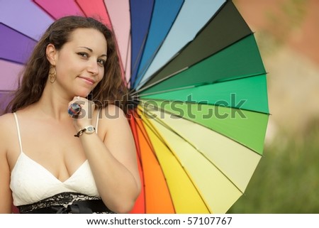 young and beautiful woman posing with rainbow umbrella