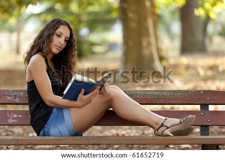 beautiful woman sitting on bench park reading book