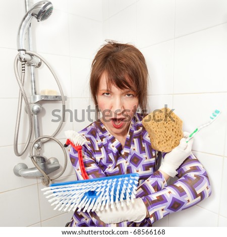 funny woman holding brushes ready to wash bathroom shower