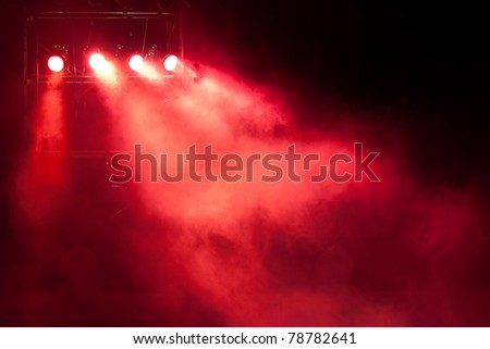 concert stage with red spot light and smoke