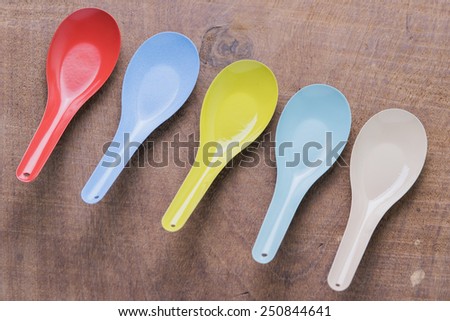 Colourful spoon vintage kitchen utensils on a wooden background.
