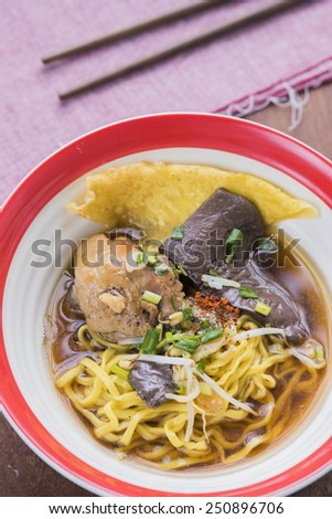 Chicken noodle soup from wheat noodles in broth with vegetables and meat.