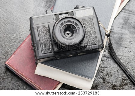 Retro camera and a diary on vintage black wooden backgrounds.