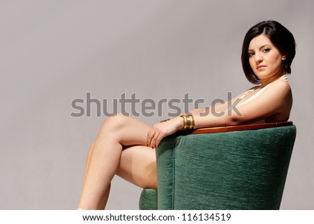A lady in a green chair isolated on gray