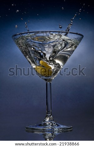 Martini cocktail splash with an olive close view
