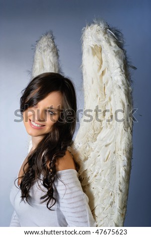 Young woman wearing angel wings smiling