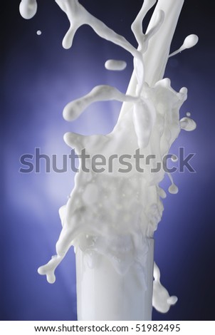 Morning start concept - milk splashing in a glass