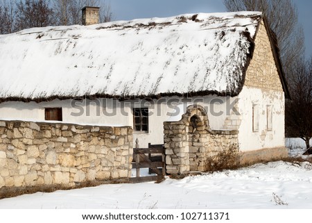 Slavonic village hut with a patio covered with snow