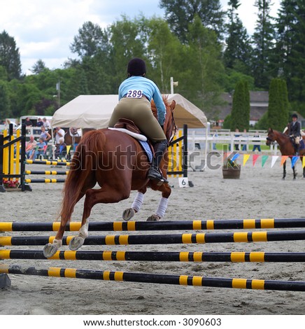 horse and rider taking jump in a local show jumping competition