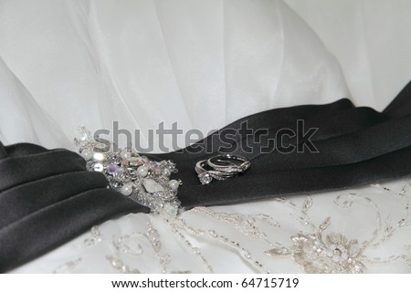 Platinum wedding rings laying on wedding gown.