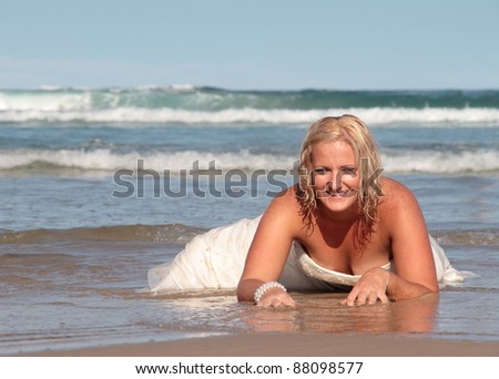 Bride doing a sexy crawl on the beach during trash the dress.