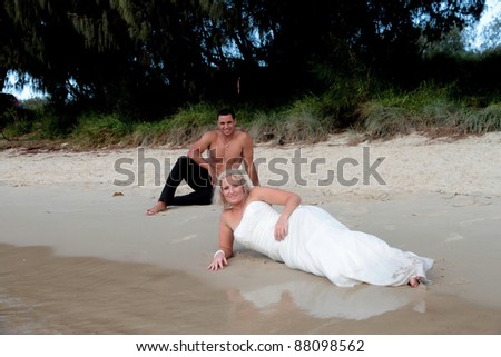 Bride and groom relax on beach during Trash the Dress