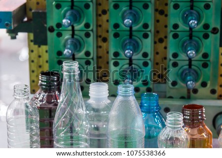 The various type of plastic bottle product with injection mold background.Drinking container manufacturing processing.