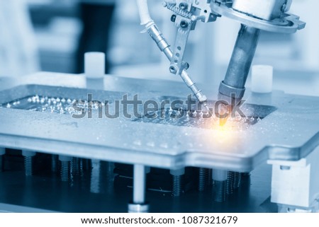 The soldering robot welding the circuit board in the light blue scene with the lighting effect.