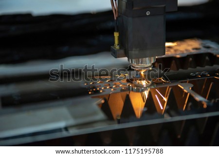 The CNC fiber laser cutting machine cutting the stainless pipe or tube  with the sparking light. Modern sheet metal manufacturing process.