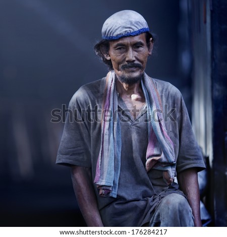 KUALA SEPETANG, MALAYSIA  - MAY 28: Unidentified workers in a charcoal factory standing alone waiting for his partner on  May 28, 2013 in Kuala Sepetang, Malaysia.