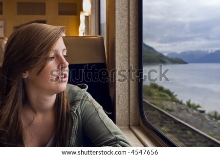 A young girl gazes out the window of a dining car on the Alaska Railroad