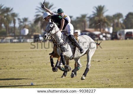 Two polo players nearly collide near ball