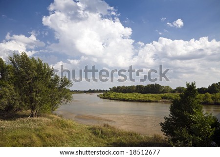 The Arkansas River meanders over the plains north of Wichita, Kansas under a partly cloudy sky