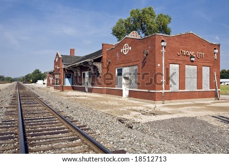 Old small-town railway station sits abandoned along a single track in Strong City, Kansas