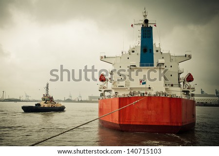 Tanker ship being tugged into a port