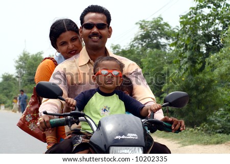 a road scene in India - four people on one bike