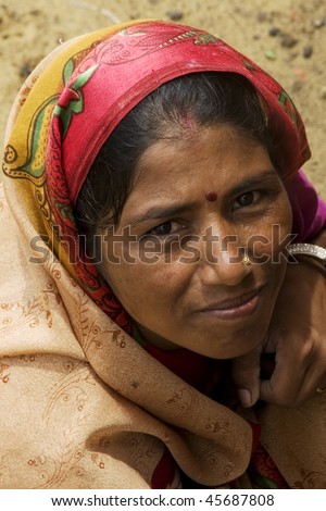 AGRA, INDIA - JUNE 18: Portrait of a senior Indian woman stands in front of temple on June 18, 2008 in Agra, India. Local women wear colorful saree (sari) as traditional clothing.