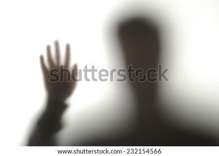 blurred silhouette of a man with his hand up