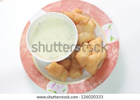 Deep fried dough sticks and a cup of soybean milk on tray