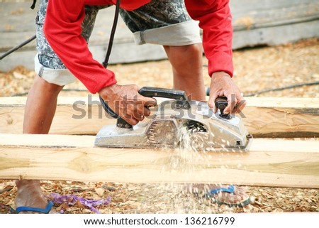 Hand of a carpenter using wood planer