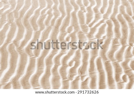 A wave of sand after the sea waves swash the beach.