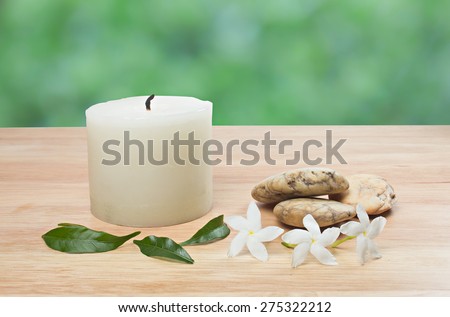 aroma candle on wood floor with green bokeh back ground.