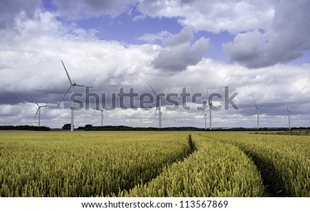 Wind farm in a wheat field and a storm brewing, near Lisset, Yorkshire, UK