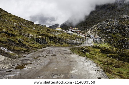 Sela Pass, Tawang, Arunachal Pradesh, India. View of the high mountain pass at 13,700ft showing the main road between Assam and Tawang, and a mist rolling in from the mountain backdrop.