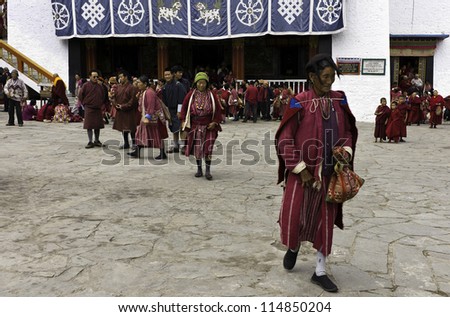 TAWANG - SEPTEMBER 21: Unidentified devotess in traditional dress and hats emerge from within the ancient Buddhist monastery on September 21, 2011 at Tawang, Arunachal Pradesh, India.