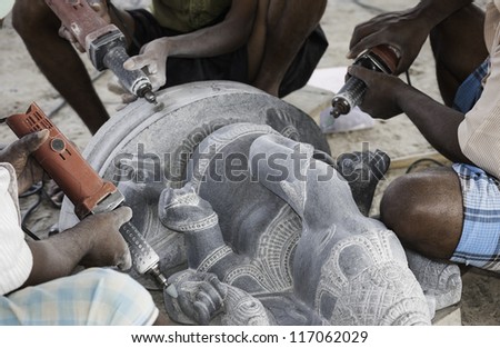 MAMALLAPURAM, INDIA - NOV 23,2011: Artisans use modern tools but ancient skills to create a large granite sculpture of God Ganesha on November 23, 2011 in Mamallapuram, Tamil Nadu, south India.