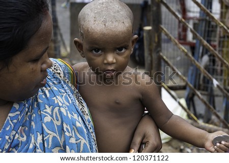 KOLKATA, INDIA - AUGUST 17: An unidentified mother with her young child begs for alms near the Kalighat Hindu temple on August 17, 2011 in Kalighat, Kolkata, India.