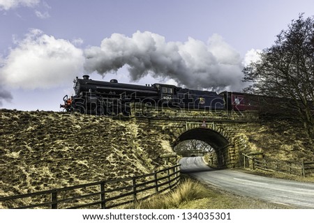 GOATHLAND, UK - APRIL 01: Vintage steam train comes out of winter hanger into bright spring sunshine on the Easter holiday run April 01, 2013 between Whitby and Pickering near Goathland, Yorkshire, UK