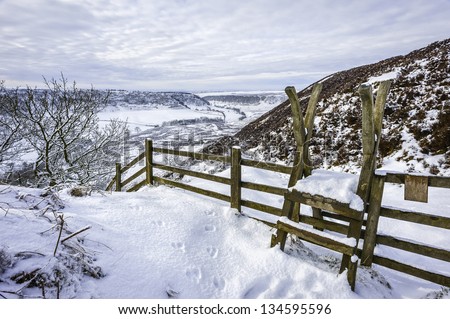 Levisham, Yorkshire, UK. Hole of Horcum and wooden step for ramblers in the early morning after a heavy snow storm near the villages of Levisham and Goathland, Yorkshire, UK.