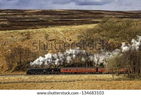 GOATHLAND, UK - APRIL 01: A vintage steam train under full steam marks the arrival of spring with the annual Easter run across the North York Moors on April 01, 2013 near Goathland, Yorkshire, UK.