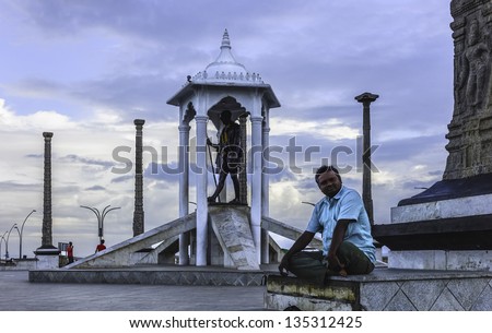 PUDUCHERRY, INDIA - NOVEMBER 11: an unidentified male rests after  exercise and meditation at dawn alongside Gandhi\'s famous salt march statue on November 11, 2012 in Puducherry, south India.