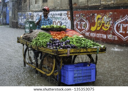 VARANASI, INDIA - AUGUST 11: monsoon rain and flash flood yet a street vendor continues to sell vegetables on the street on August 11, 2011 in Varanasi, Uttar Pradesh, India.