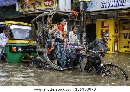 VARANASI, INDIA - AUGUST 11: monsoon rain and dangerous flash flood yet for these rickshaws and passengers it\'s business as usual on August 11, 2011 in Varanasi, Uttar Pradesh, India.