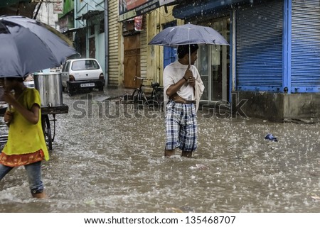 VARANASI, INDIA - AUGUST 11: Heavy monsoon rain causes a flash flood and this man finds himself momentarily stranded on August 11, 2011 in Varanasi, India.