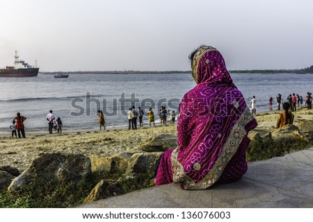 FORT KOCHI, INDIA - JANUARY 22: local residents enjoy the sandy beach at sunset near a Chinese fishing net at weekend on a Hindu festival on January 22, 2012 in Fort Kochi, Kerala, India.