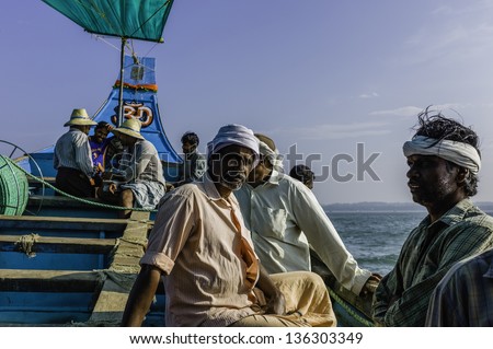 KANNUR, INDIA - DECEMBER 22, 2011: fishermen in traditional wooden boat set out to deep sea on a fishing trip for sardine on December 22, 2011 from Mapilla Bay Harbour, Kannur, Kerala, India.