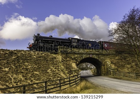 GOATHLAND, UK - APRIL 04: A vintage steam train makes the annual Easter run between Grosmont and Pickering  on April 04, 2013 near the village of Goathland, Yorkshire, UK.